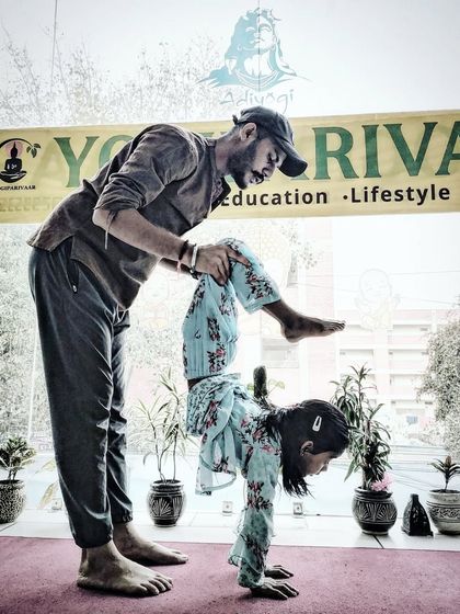 Another angle of a supported handstand for a child, a playful way to build upper body strength.