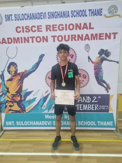 A proud moment for Zehn, posing with his silver medal in front of the tournament banner. His hard work is an inspiration to his peers.