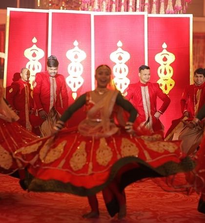 The energy of a royal wedding entry is unmatched. Here, our dancers perform a traditional welcome in vibrant red costumes, setting a festive and grand tone for the couple's Jaimala ceremony.