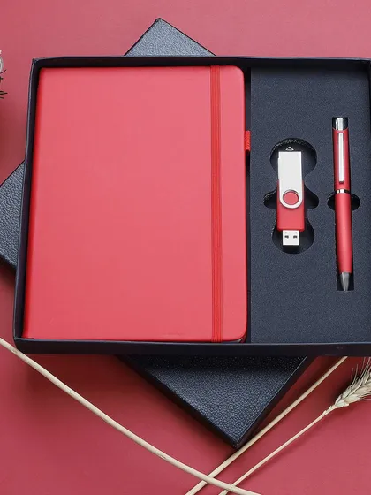 We deliver clean, sharp product photography for corporate merchandise. This image of a premium red gift set, containing a notebook, pen, and USB drive, is an example of our catalog-ready shots, presented in its packaging for a professional look.