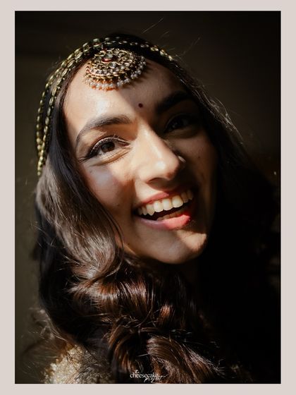 A close-up of the bride's happy, sun-kissed face. The natural light brings out her beautiful smile.