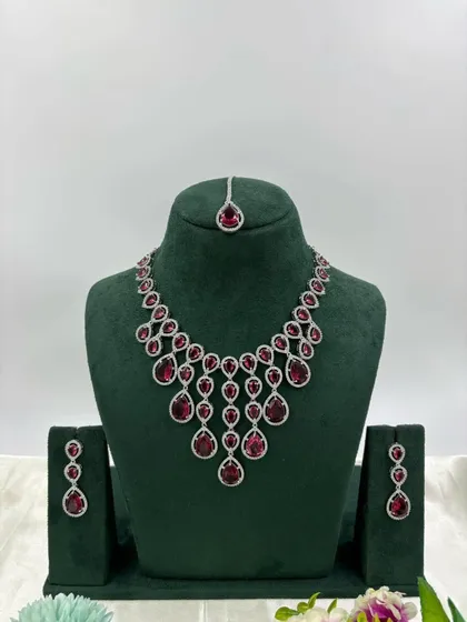 The delicate AD necklace with ruby-red stones.