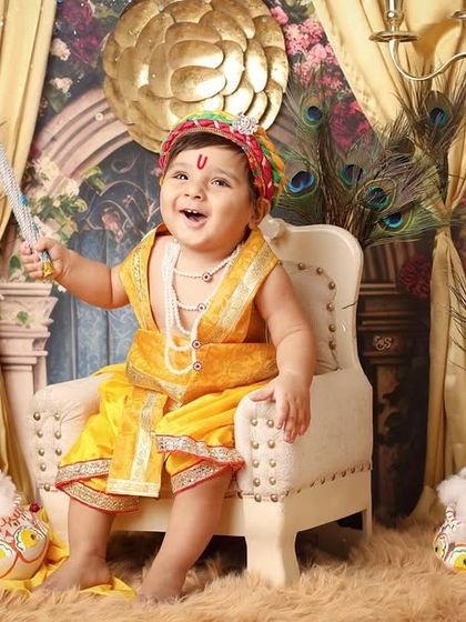With a morpankh in hand, this little Krishna is full of divine charm. The elaborate set, complete with a throne and a Nandi cow figure, makes for a truly memorable Janmashtami photoshoot.