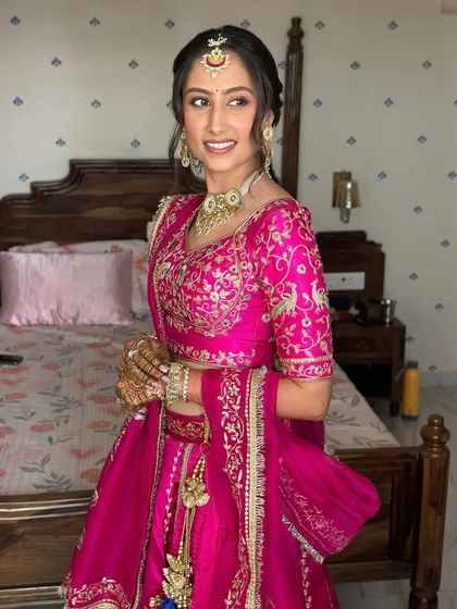 This bride is glowing. The makeup gives her a sun-kissed radiance with flushed cheeks, perfect for a daytime pre-wedding function.