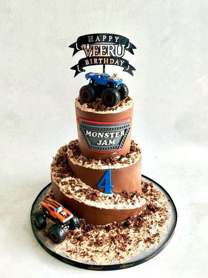A Monster Jam cake for Veeru's birthday. The spiral ramp design with chocolate "dirt" and monster trucks is perfect for a little adventurer.