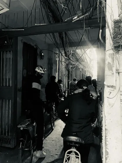 A group of cyclists navigates a dark alley, with a sliver of sunlight breaking through. This atmospheric shot captures the adventurous spirit of our Old Delhi tours.