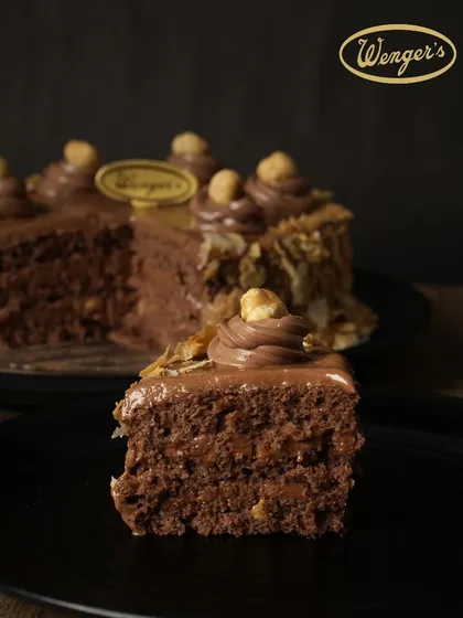 A perfect slice of our Nutella Hazelnut Cake. You can see the rich texture of the chocolate sponge and the generous layers of creamy Nutella filling.