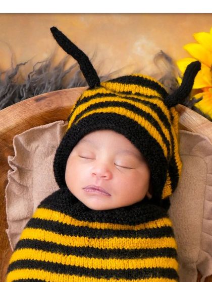What could be sweeter than a little honeybee? This adorable themed shoot features a knitted bee costume and a bright sunflower, creating a cheerful and unique portrait.