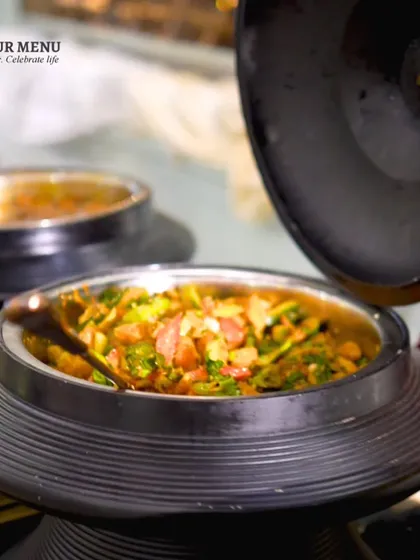 A close-up of a Chinese dish in an elegant black serving bowl, part of our beautifully designed Pan-Asian counter.