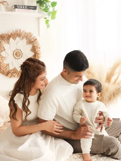 A picture of a happy family. This portrait, set in our boho-chic studio, shows a family relaxed and enjoying their time together. The natural textures and light create a warm and inviting atmosphere.