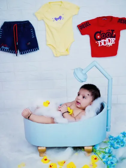 A relaxed baby boy in our miniature bathtub prop, surrounded by bubbles.