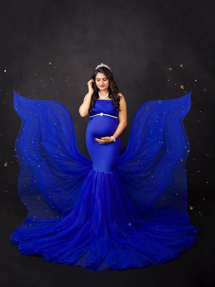 A royal blue gown with sparkling fabric wings creates a magical, celestial effect. This is for the mother-to-be who wants to feel like a star.