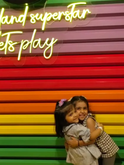 Two sisters share a sweet hug in front of our iconic and colorful pencil wall.