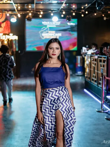 A closer shot of the model in the blue and white outfit, capturing her confident expression and the details of her look.