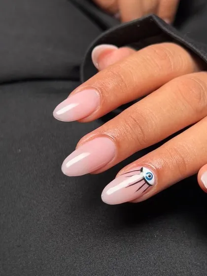 A simple yet chic set with a nude base and a single evil eye accent nail. This work by a student shows that sometimes, less is more.