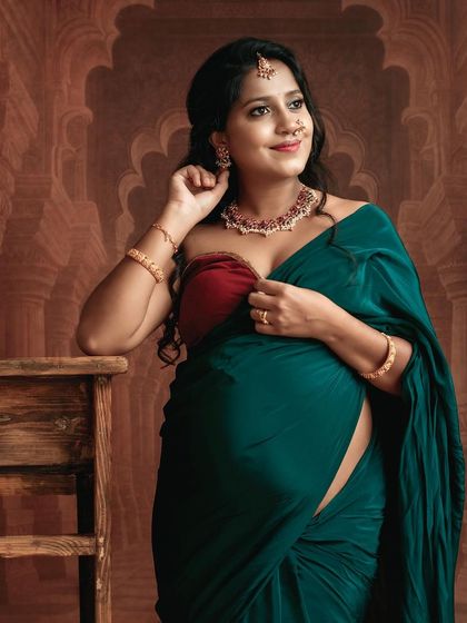 The joy and anticipation are radiant in this portrait. The mom-to-be looks stunning in her green saree, accessorized with traditional jewelry.