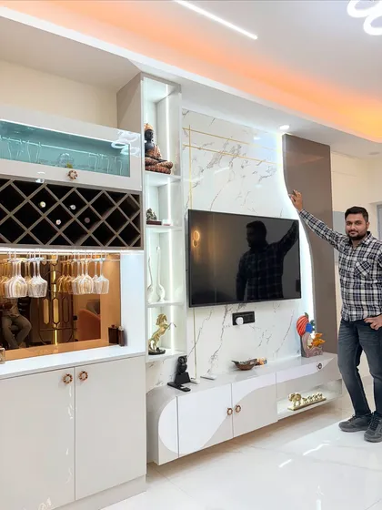 A perfect example of a living area that combines entertainment and elegance. This showcases a custom-designed TV unit with a marble-finish back panel, seamlessly integrated with a stylish bar and crockery unit, complete with dedicated wine racks and glass holders.