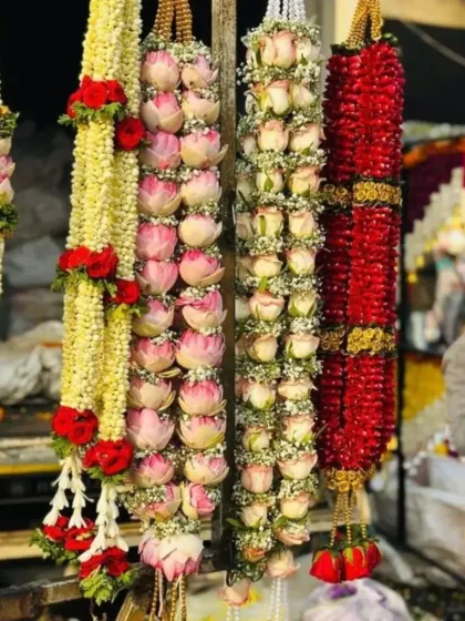 We specialize in creating fresh, handcrafted wedding garlands. This photo shows a variety of jaimalas, including ones made with lotus buds, roses, and jasmine, ready for the ceremony.