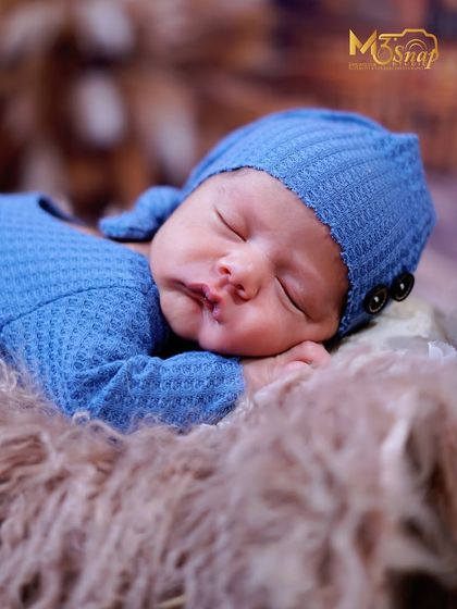 Another beautiful angle of this sleeping baby boy. The soft lighting and cozy textures ensure the focus remains on the baby's serene expression.