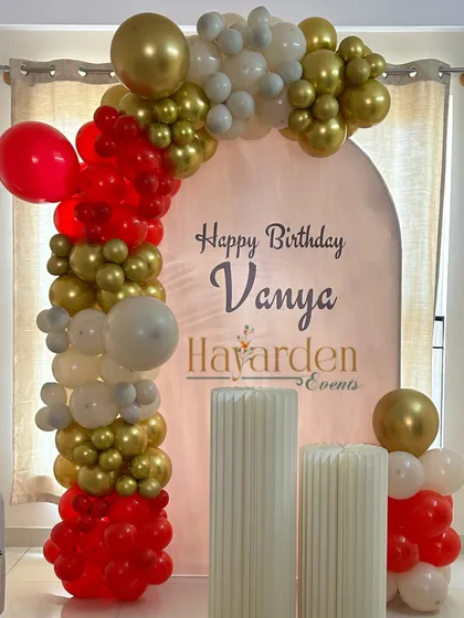 A modern arched backdrop panel, personalized with the birthday name. This is a very trendy and clean look.