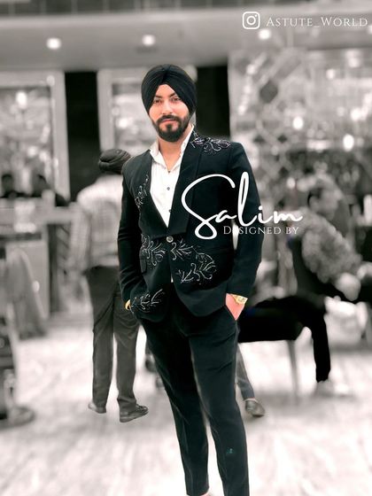 A client wearing a black suit with delicate white embroidery on the shoulders and pockets. This is a great example of a more understated yet custom look.