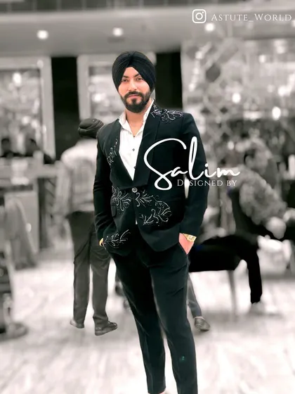 A client wearing a black suit with delicate white embroidery on the shoulders and pockets. This is a great example of a more understated yet custom look.