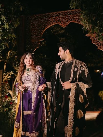 The couple makes their entrance for the "Perfumed Orchard" Mehfil. The path was lit with candles and led through a beautiful wooden arch, setting a romantic tone for the evening.