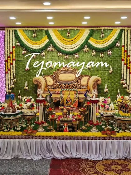 A wide view of a baby shower setup with a green floral backdrop and hanging garlands. The plate decoration is extensive and beautifully arranged.