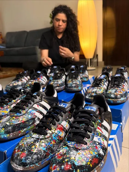Here I am with a large commission of nine pairs of Adidas Sambas. Each shoe was hand-painted with a unique splatter design for a private client, showing how I can handle bulk orders for events or teams while ensuring every single piece is a work of art.