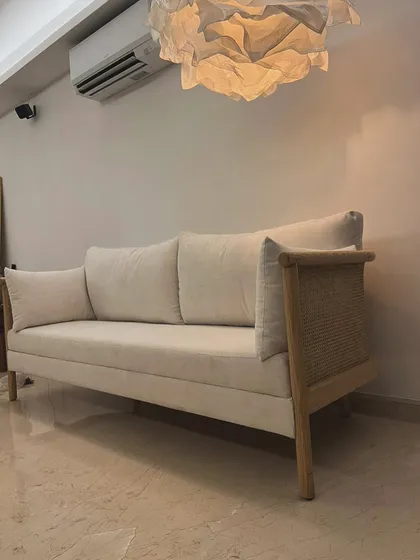 This elegant sofa, made from solid oak with natural cane side panels, brings a light and airy feel to the living room. The neutral fabric and clean lines make it a versatile piece for modern homes.