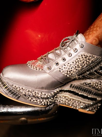 A unique detail shot of the bride's customized, embellished platform sneakers. This photo highlights her personal style and the fun details of her wedding look.