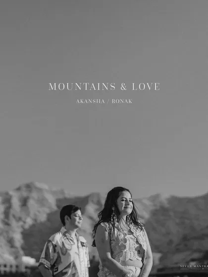 A black and white portrait titled "Mountains & Love." This artistic shot from a beachside pre-wedding shoot in Oman has a timeless, classic feel.