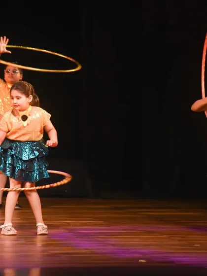 Young performers in action during their hoop routine, captured mid-spin. This dynamic shot shows the movement and skill involved in our prop-based choreography.