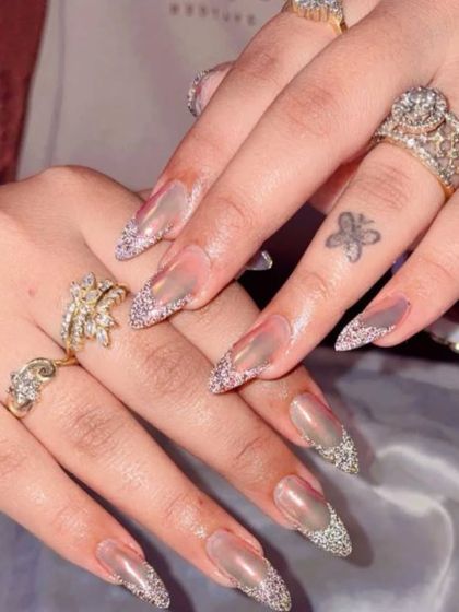 A super glam look with clear extensions and a diagonal tip of fine silver glitter.