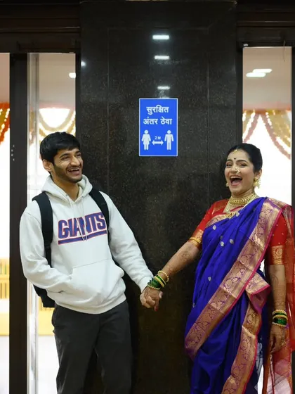 I love it when couples bring their own brand of humor to the wedding day. Sanika was all ready for her portraits, but Shubhankar showed up in a hoodie. The "Surakshit Antar Theva" sign was just too perfect. It’s these funny, real life moments that tell your unique love story.