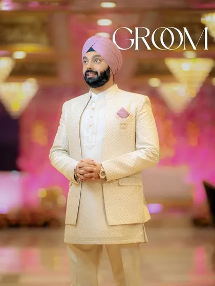 A handsome solo portrait of the groom, Sanjit, in his elegant off-white Jodhpuri suit and lavender turban.