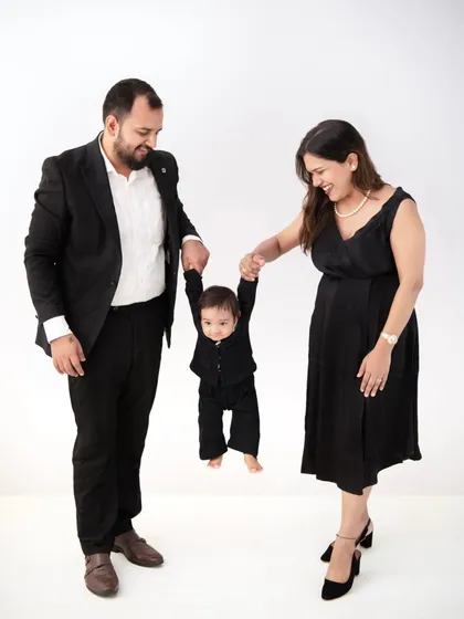 A fun and dynamic pose, with the parents swinging their son. This image perfectly captures the playful energy of a young family.