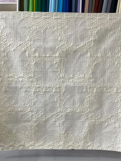 The back of the daisy quilt, where the quilting pattern is clearly visible.