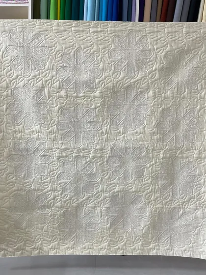 The back of the daisy quilt, where the quilting pattern is clearly visible.