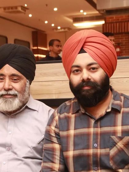 A portrait of a father and son from the Sikh community, seated together at a restaurant. We capture candid and posed portraits of family members.