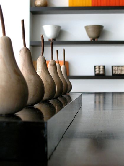 A close-up of the minimalist yet artistic decor in our hotel. These wooden pears lined up on a sleek black surface show our attention to detail and unique design choices.
