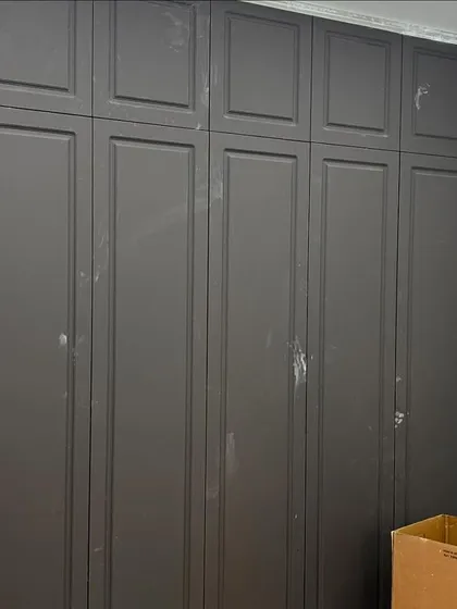 A classic and elegant storage solution. This photo shows a finished wardrobe with dark grey panelled doors, providing a sophisticated contrast to the lighter walls of the bedroom.