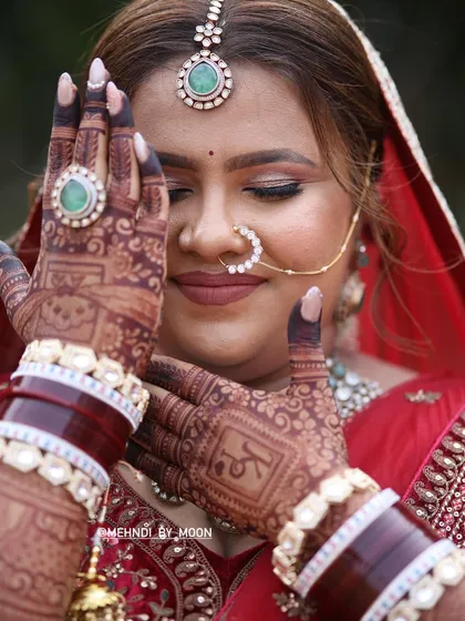 A professional photo of the bride showing her hands. You can clearly see the initial 'K' hidden in her design, and the stain has developed into a beautiful deep maroon color.