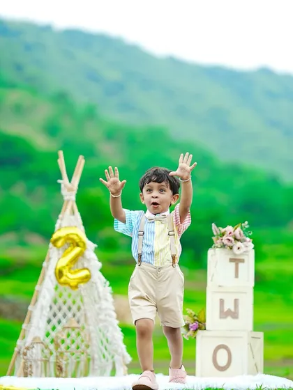 Capturing the pure energy of a two-year-old. This outdoor session uses the beautiful green landscape as a natural backdrop, complemented by our boho-style props like a macrame teepee and "TWO" blocks to celebrate his second birthday milestone.