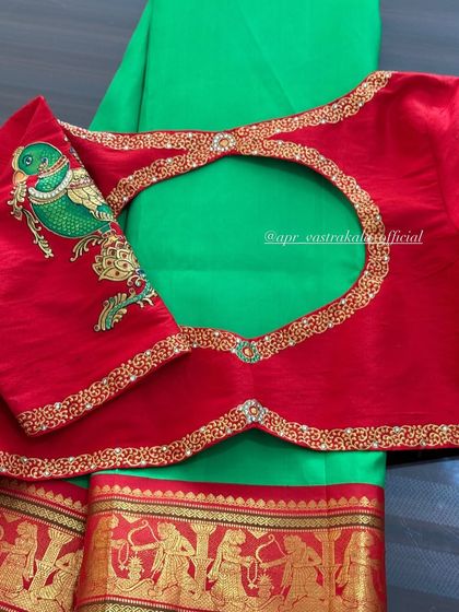 A red blouse with a painted parrot on the sleeve and a beautifully embroidered back cutout.