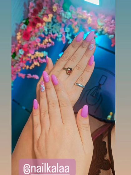 A pretty pastel purple manicure with delicate floral accent nails. This is a soft and feminine look perfect for spring.