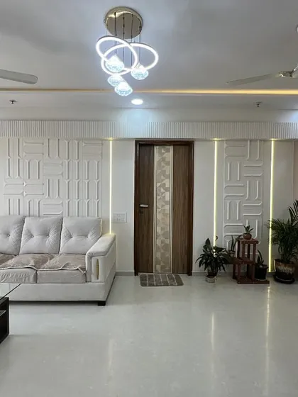 This living room showcases a serene, contemporary aesthetic with a neutral color palette. The textured feature wall with integrated lighting adds depth and character to the space.