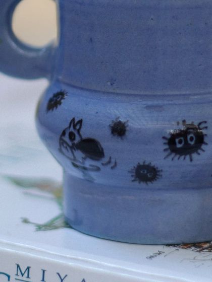 A close-up of the hand-painted Ghibli characters on my periwinkle blue mug. The little soot sprites and gremlins add a touch of playful charm.