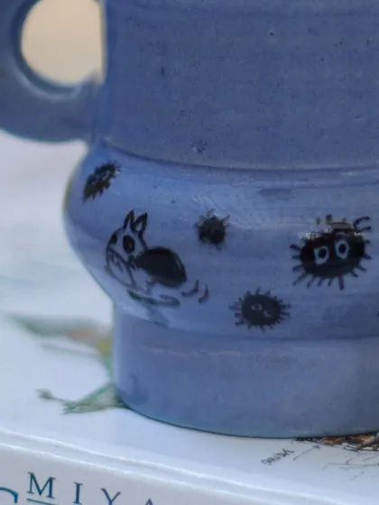 A close-up of the hand-painted Ghibli characters on my periwinkle blue mug. The little soot sprites and gremlins add a touch of playful charm.
