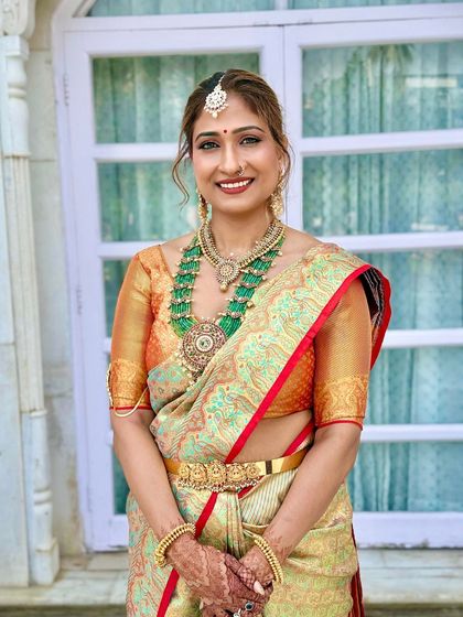 This bride's look is a perfect harmony of color, with the green in her necklace echoed in her makeup. The result is a cohesive and regal bridal appearance.